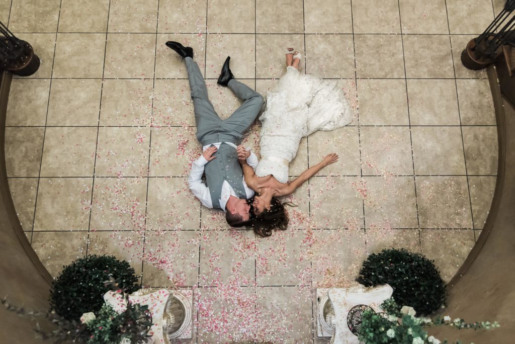 Wedding venue in Colorado - bride and groom laying on the floor in petals