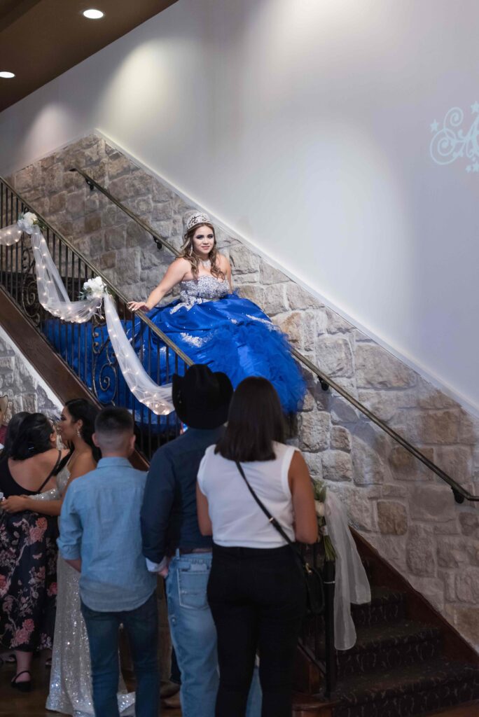 Royal blue quinceanera dress with quince entering on stairs